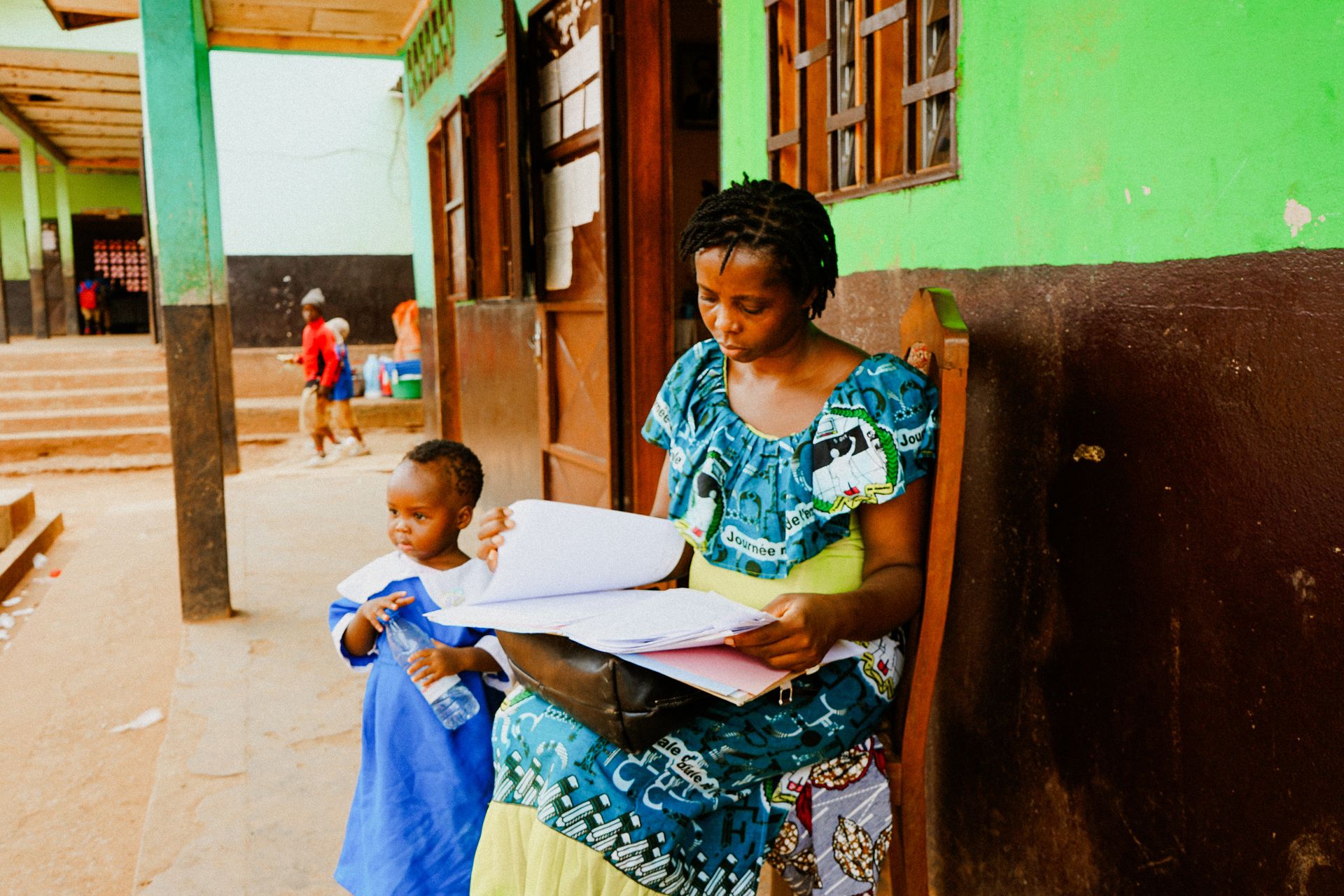 A mother reading with her child outside a school
